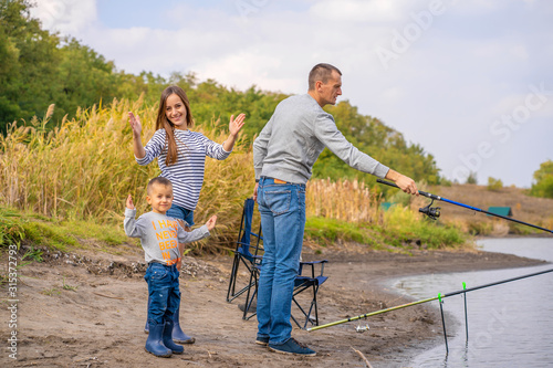 A happy family spends time together they teach their son to fish. © Kate