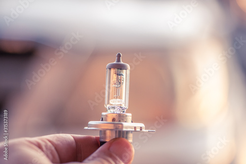 Car headlight bulb holding in hand. photo