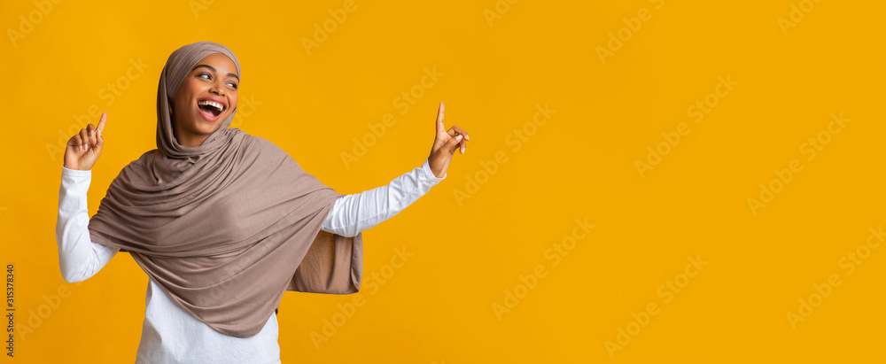 Carefree afro muslim girl in hijab looking aside at copy space - obrazy, fototapety, plakaty 