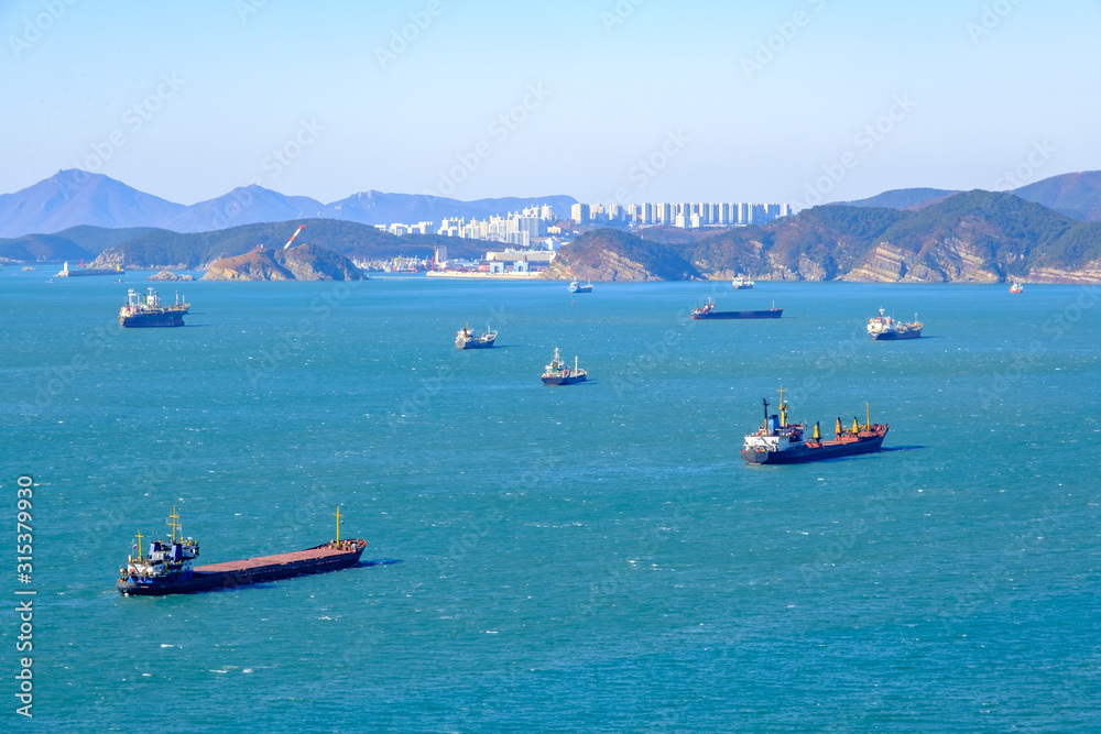 shipping cargo and fishing boat and building with mountain background