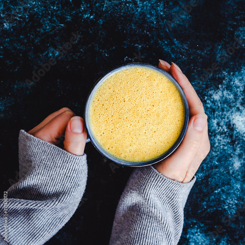 Woman holding a cup of turmeric milk photo