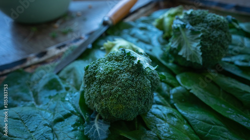 Broccoli and spinach leaves on a table. Still life
