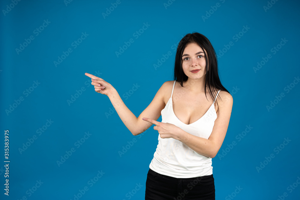 Front view of cheerful girl pointing with fingers isolated on blue background