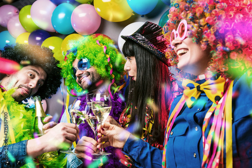 Glückliche Party Freunde feiern karneval und stoßen mit Sekt an.