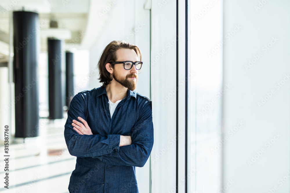 Handsome young businessman with folded arms in the office. Cheerful self confident man with crossed hands portrait. Business success concept Handsome young businessman with folded arms in the office. Cheerful self confident man with crossed hands portrait. Business success concept