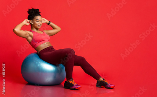 Young sporty black girl working out with fitness ball photo