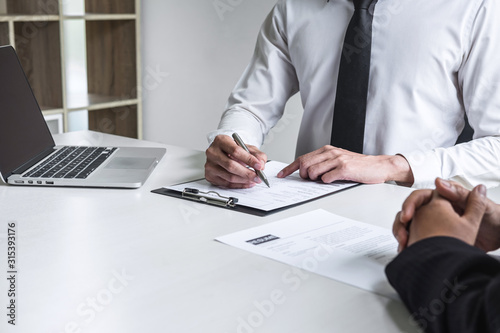 Employer or committee holding reading a resume with talking during about his profile of candidate, employer in suit is conducting a job interview, manager resource employment and recruitment concept