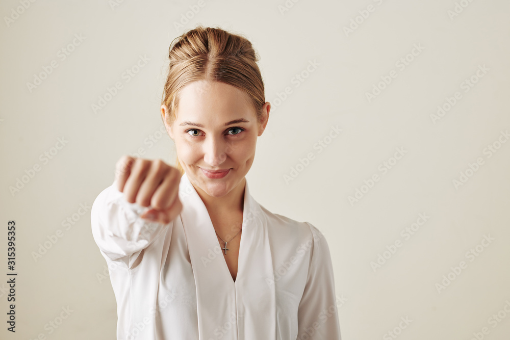 Successful Caucasian woman giving fist bump looking at camera horizontal srudio portrait Successful Caucasian woman giving fist bump looking at camera horizontal srudio portrait