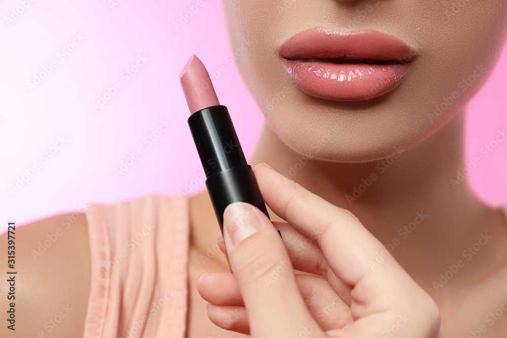 Obraz premium Woman with glossy lipstick on pink background, closeup