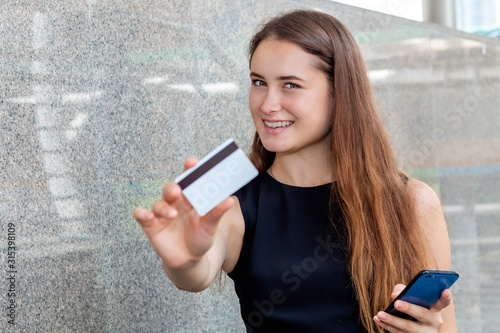 Smart Caucasian woman buying online with a credit card and smart phone application.