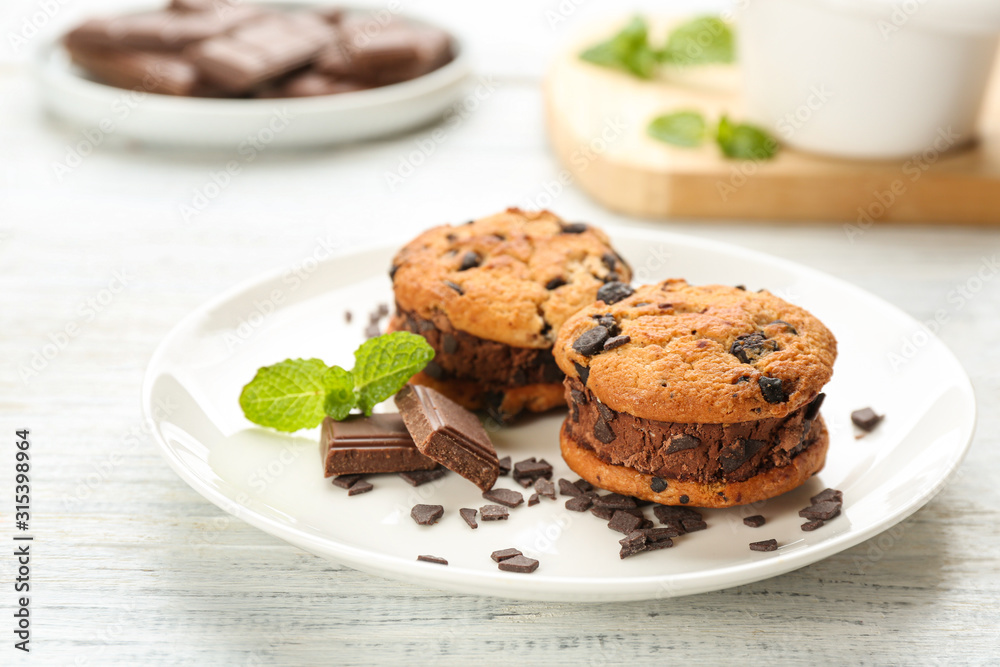 Sweet delicious ice cream cookie sandwiches and chocolate on white wooden table Sweet delicious ice cream cookie sandwiches and chocolate on white wooden table