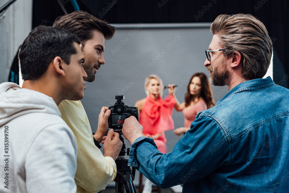 selective focus of art director standing with photographer and assistant