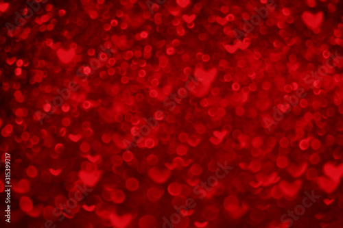 Valentines day abstract defocused red bokeh background. Hearts and circles bokeh lights. Romantic glittering blurred texture.