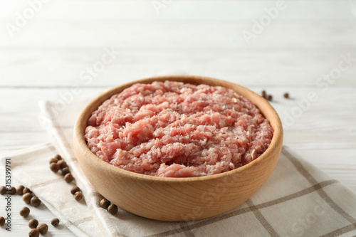 Towel, spices and bowl with minced meat on wooden background, close up