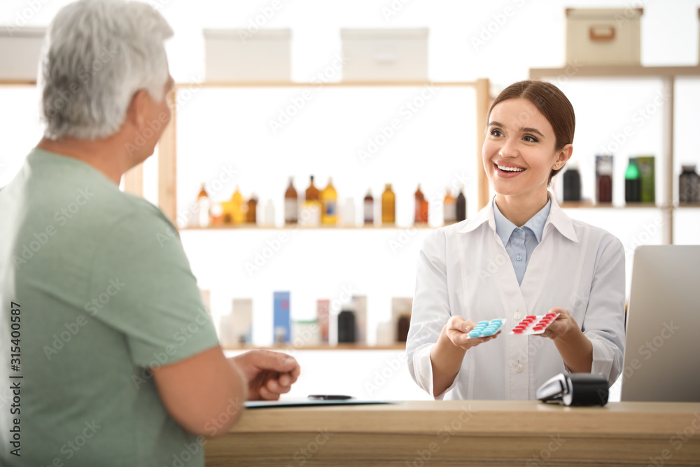 Obraz premium Professional pharmacist working with customer in drugstore