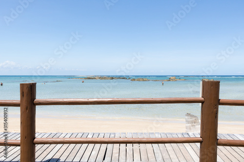 View of deserted beach and wooden deck. Blue Ocean Background. Brazil. Bahia. Morro de Sao Paulo.