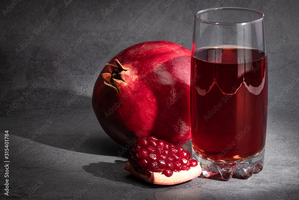 Pomegranate juice with pomegranate on a dark background Pomegranate juice with pomegranate on a dark background
