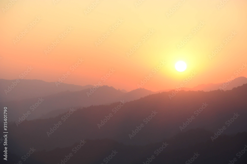Blurred sunset silhouette  mountain landscape background with orange sky.