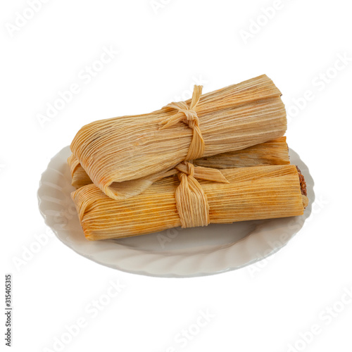 three pork tamales on a plate isolated on white background photo