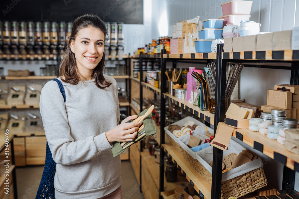 Woman chooses and buys products in zero waste shop.