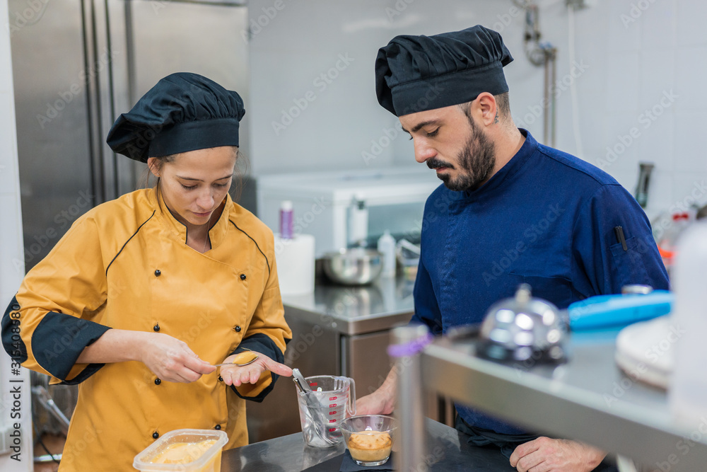Cook with colleague serving food on plate Cook with colleague serving food on plate