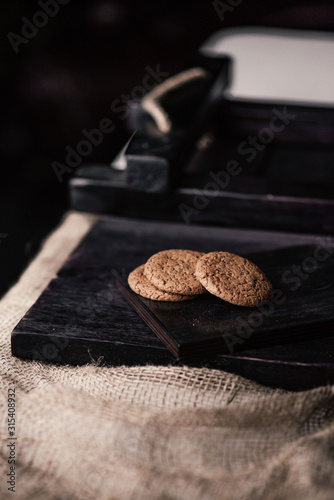 Rustic, dark and blurred background. corn. On the table are oatmeal cookies.