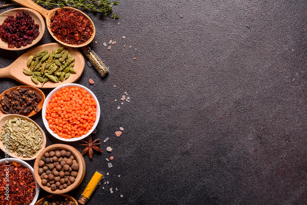 A set of spices and herbs. Indian cuisine. Pepper, salt, paprika, basil and other on a dark background A set of spices and herbs. Indian cuisine. Pepper, salt, paprika, basil and other on a dark background