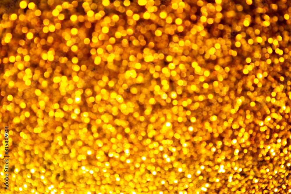Golden sparkles bokeh on a dark background Golden sparkles bokeh on a dark background