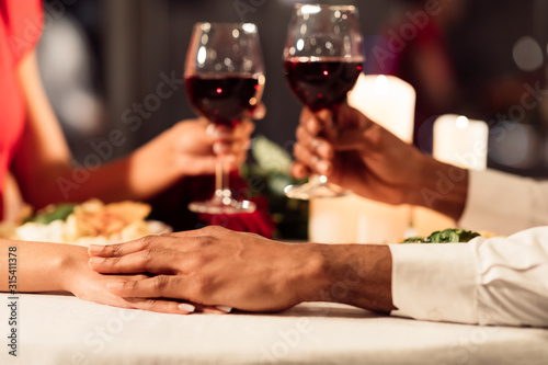 Couple Holding Hands And Toasting Celebrating Valentine In Restaurant, Cropped