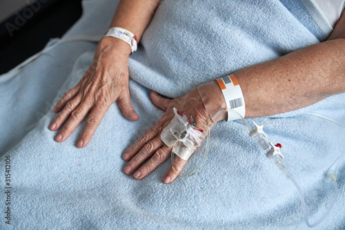 Crop elderly patient receiving medicine through cannula photo