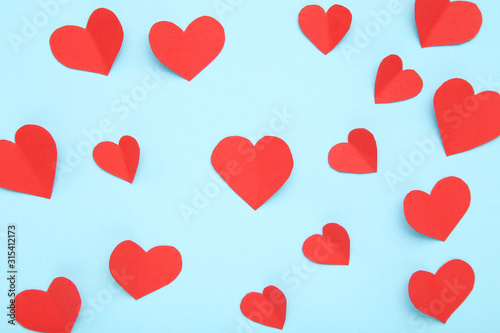 Red paper hearts on blue background