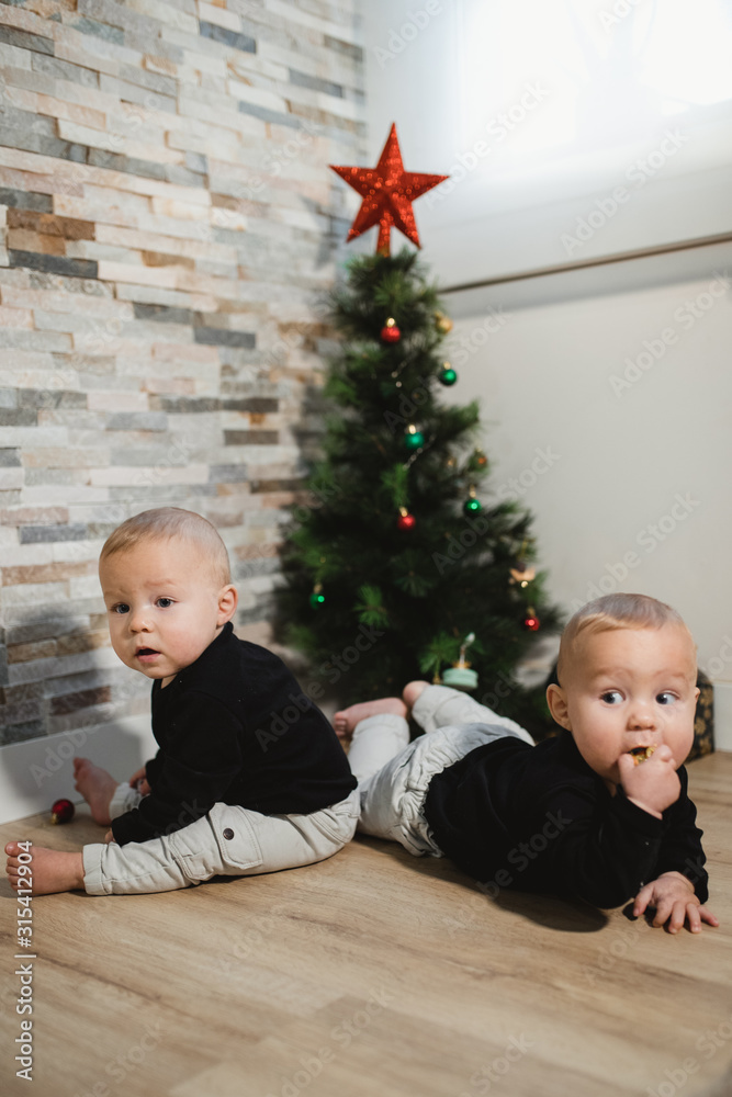 Happy babies near Christmas tree and gifts Happy babies near Christmas tree and gifts