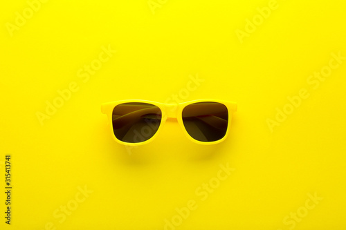Modern sunglasses on yellow background