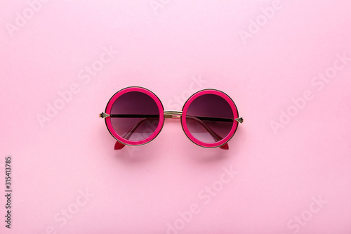 Modern sunglasses on pink background