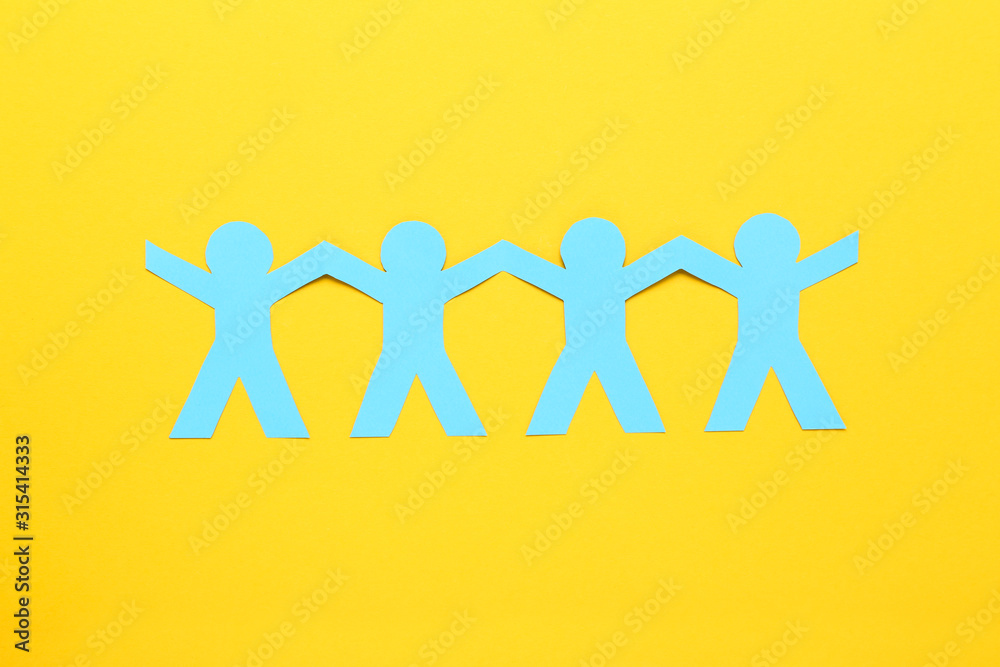 Paper chain people on yellow background Paper chain people on yellow background