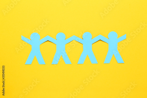 Paper chain people on yellow background