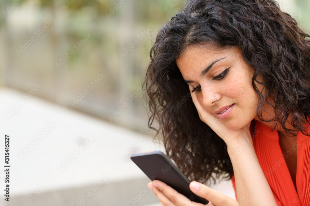 Fototapeta premium Pensive woman reading message on smart phone