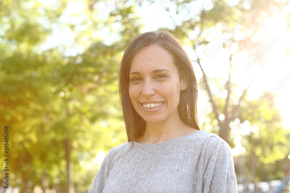 Portrait of a happy adult woman looking at camera in a park Portrait of a happy adult woman looking at camera in a park