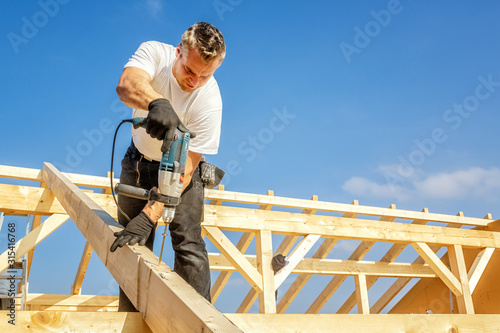 Papier peint Carpenter at Work, Fixing a Rafter with a Long Screw