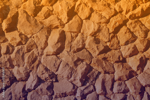 Beautiful rough marble stone wall background illuminated by golden hour sunlight during a hot summer afternoon