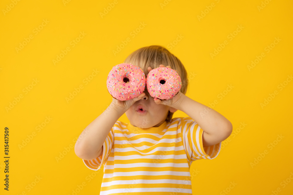 Happy child holding glazed donut - obrazy, fototapety, plakaty 