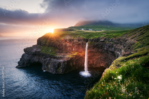Incredible sunset view of Mulafossur waterfall in Gasadalur village, Vagar Island of the Faroe Islands, Denmark. Landscape photography