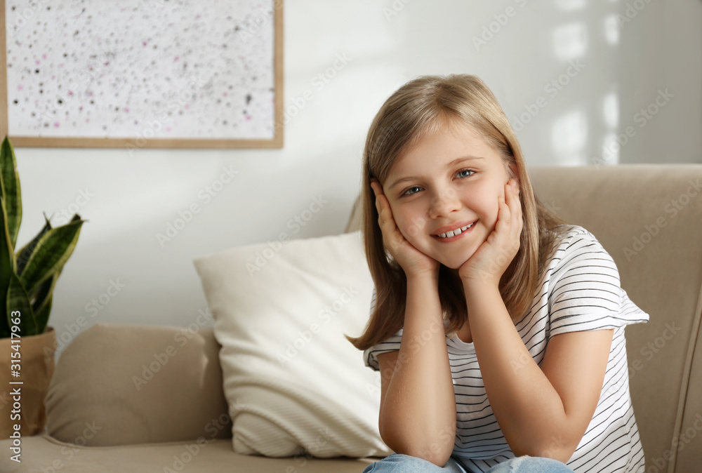 Cute little girl on couch at home. Space for text Cute little girl on couch at home. Space for text