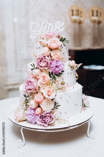 Cake traditional anniversary birthday wedding three-layer. White wedding cake with pink flowers for wedding banquet. Delicious wedding reception. Copy space. Celebration party concept. Trendy Cake. © MONIUK ANDRII