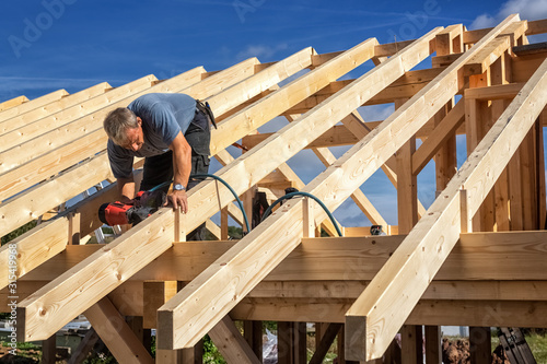 Valokuvatapetti Carpenters Setting up a Half-timbered Building and the Roof Structure