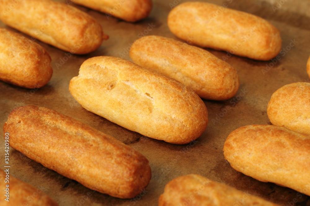 Freshly baked choux pastry. Making Eclair. Freshly baked choux pastry. Making Eclair.