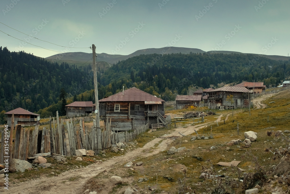 mountain village with traditional wooden houses in Georgia near the Goderdzi Pass at september evening  