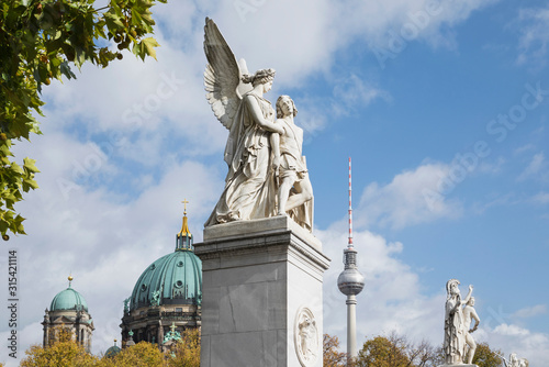 Germany, Berlin, Nike Assists Wounded Warrior statue with Berlin Cathedral and Berlin TV Tower in background photo