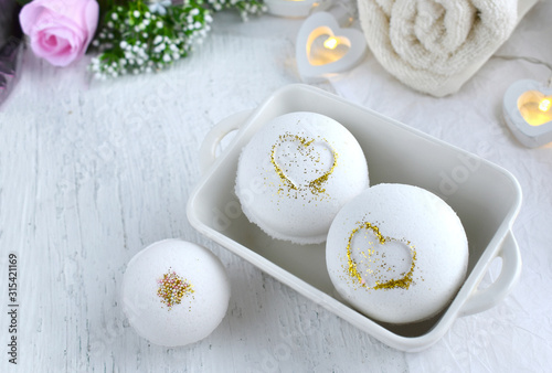 Bath aroma bombs set with heart, towel on white background. Romantic spa luxurios composition. Love concept for Valentines day, Mothers day or wedding