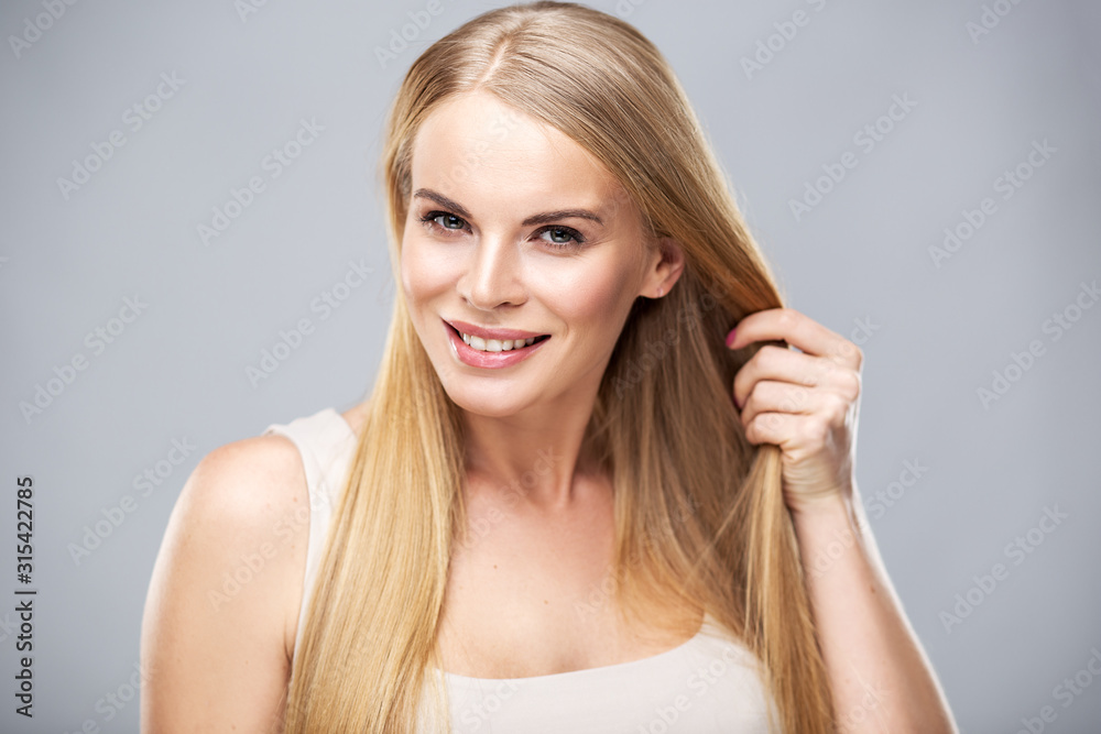 Beautiful blonde woman with shiny long straight hair and natural fresh make up. Fashion beauty portrait isolated Beautiful blonde woman with shiny long straight hair and natural fresh make up. Fashion beauty portrait isolated